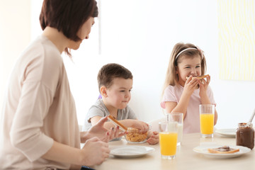 Mother and children having breakfast at home