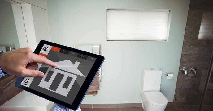 Hand using smart home app on tablet PC in washroom