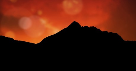 Silhouette mountain against orange sky