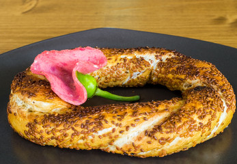 Closeup of traditional Turkish Pastry (Simit) with salami served on a grey plate