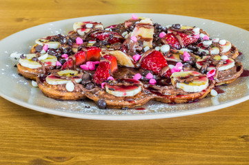 Closeup of fruity Belgian waffles with  chocolate and strawberry sauce