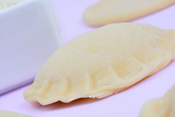 Ravioli with cheese on pink background