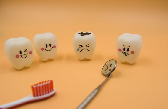 Model Cute toys teeth in dentistry on a yellow background.