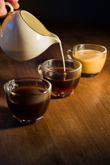 Creamer Pouring Cream into Three Glass Coffee Mugs 2