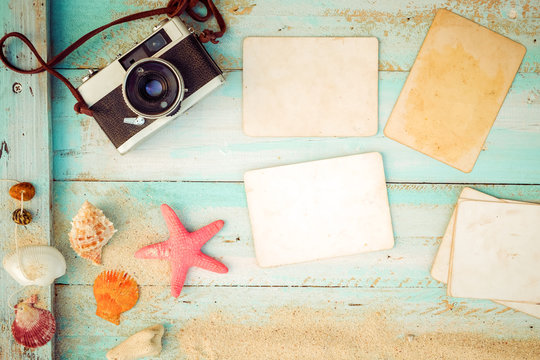 Top view composition - Blank paper photo frames with starfish, shells, coral and items on wooden table. Concept of remembrance and nostalgia in summer tourism, travel and vacation. vintage color tone.