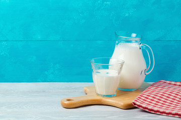 Milk on wooden table over blue background with copy space. Jewish holiday Shavuot concept