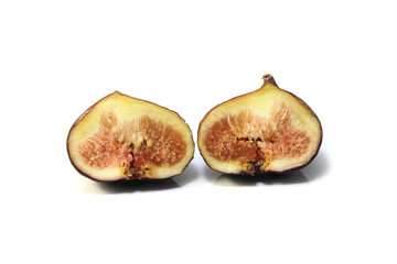 Black genoa figs cut through to show the flesh and seeds on white background.