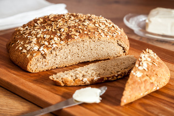 Healthy rye-wheat sourdough bread. Homemade whole grain fitness bread sprinkled with oat flakes closeup