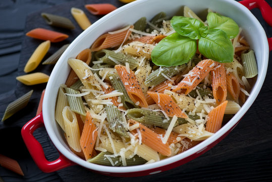 Close-up of boiled three-colored penne pasta with parmesan, high angle view