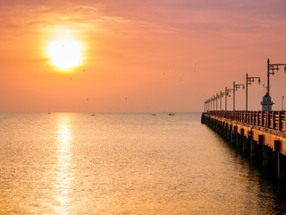 Sunrise over the sea with bridge and lighthouse