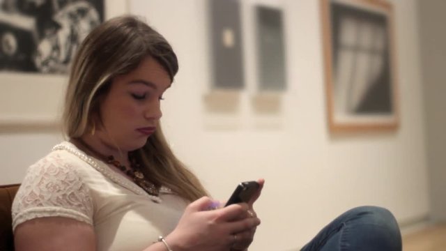 Bored attractive woman sitting in museum art gallery waiting for lame date to be over