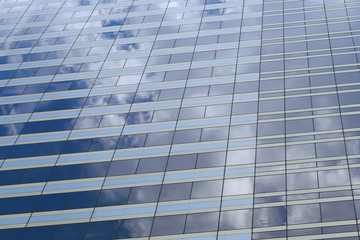 glass of the tall building with the glare of the blue sky.