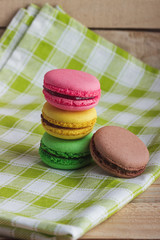 Brown, yellow, green and pink macarons on the plaid napkin