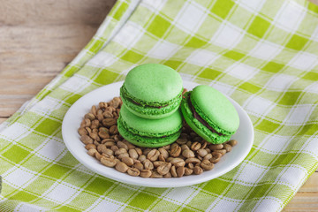 Green macarons on the plate with green coffee beans