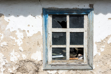 Old broken window clay stucco covered with whitewash wall defect
