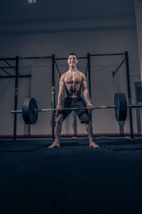 Fototapeta na wymiar bodybuilder muscular deadlift, dark indoors gym, shouting screaming