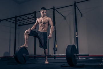 Obraz na płótnie Canvas bodybuilder standing on weights bar barbell