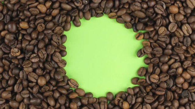 Rotation of the coffee beans lying on a green screen, chroma key.