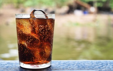 Detail cola and ice in glass in relax time on holiday