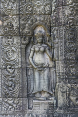 Fototapeta na wymiar Khmer devata guarding the temple shown in stone in Banteay Kdei temple in Angkor, Siem Reap, Cambodia.