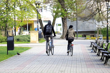 Szczęśliwa para, dziewczyna i chłopak jadą na rowerze w parku.  - obrazy, fototapety, plakaty