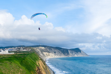 Flying tandem paragliders over the sea and near the mountains, beautiful landscape view