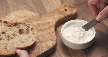 taking ricotta cheese to spread on bread, 4k photo