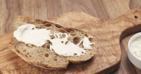 Fototapeta na wymiar spreading ricotta cheese on fresh rustic bread, 4k photo