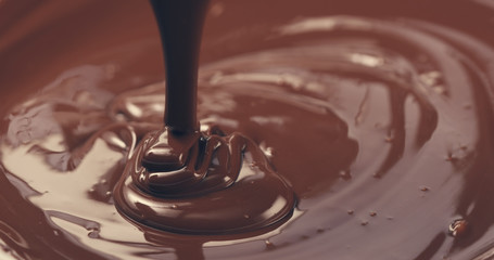 premium dark melted chocolate being poured from spoon closeup toned, 4k photo
