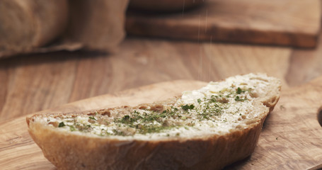 salt falling on rustic bread with butter, 4k photo