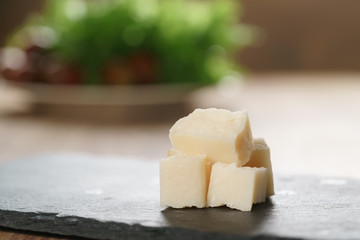 pieces of hard parmesan cheese on slate board, closeup photo