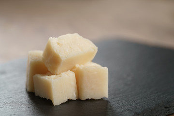 pieces of hard parmesan cheese on slate board, closeup photo