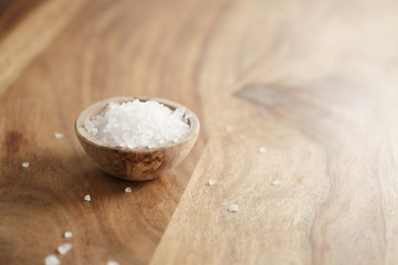 coarse sea salt in wooden bowl on table, with copy space