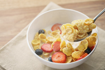 spoon with healthy breakfast with corn flakes and berries, slightly toned photo