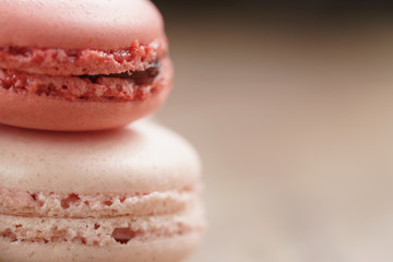 closeup shot of pink pastel colored macarons on wood table, vintage toned photo