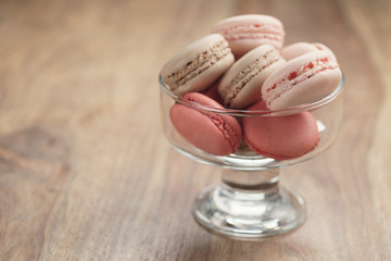 macarons with strawberry, rose and caramel flavour in glass bowl, shallow focus