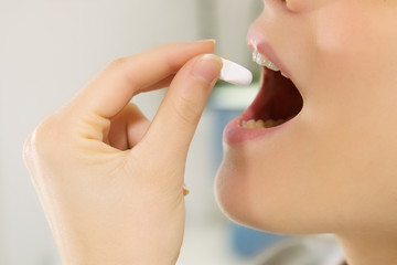 Sad sick woman taking pill medicine extreme mouth closeup