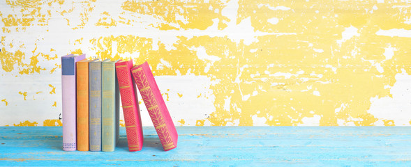 Naklejka premium row of old books, grungy background, free copy space, panoramic format