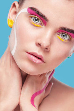 Portrait of the bright beautiful girl with art colorful painting make-up and bodyart