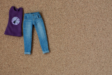 Голубые джинсы и фиолетовая майка на пробковом фоне