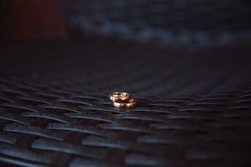 Two wedding rings laying on the dark table