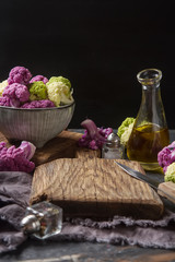 Obraz na płótnie Canvas Rainbow of organic cauliflower and Romanesco broccoli on wooden table.