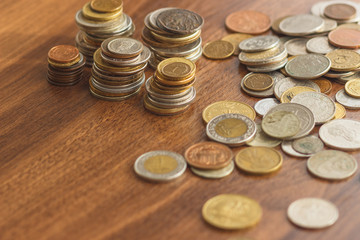 Different gold and silver collector's coins on the wooden table