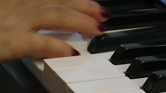 Pianist enjoys playing the piano. Hands of a woman playing music on a keyboard instrument. Fingers on the keys.