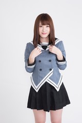 若い女性が制服を着ています。手の表情が豊かです。サイネージや広告宣伝に適した画像です。この画像の背景は、白です。