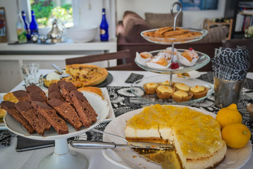 Dessert table with a selection of cookies, chocolate biscotti and cheesecake on white serving plates