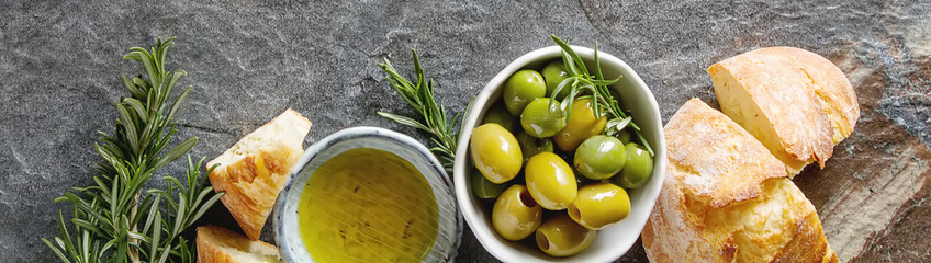 Panele Szklane  Oliwa z oliwek ze świeżymi ziołami i pieczywem. Szare tło. Włoskie i greckie jedzenie narodowe. Widok z góry