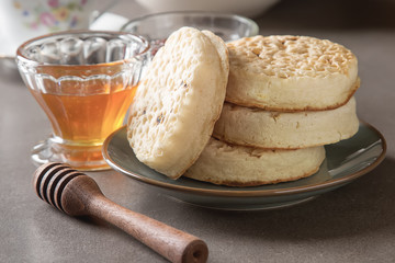 Hot Home made toasted crumpets served with honey and jams. Dark wood background. British breakfast.