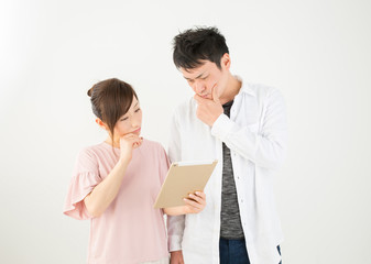 Obraz premium 困った顔でタブレットを見る男女 