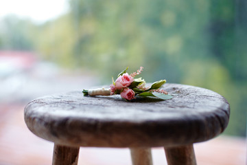 The groom's buttonhole on an old wooden stool